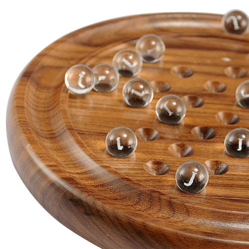  A zoomed in image of showing half the brown solitaire board and a few clear balls scattered across it. 