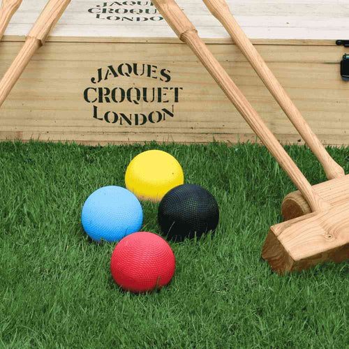  Croquet balls on lawn with wooden Jaques Box and mallets 