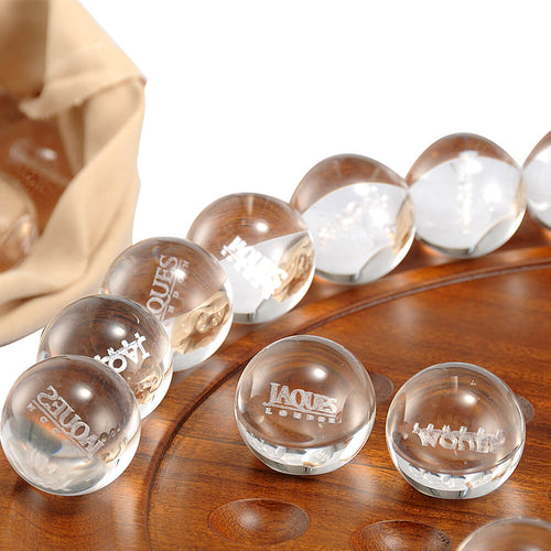  zoomed in image showing edge of brown solitaire board and clear balls with Jaques London written on them.