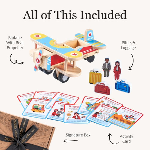 A wooden toy bi-plane set with illustrated cards, small toy figures, luggage pieces, and a signature box. 