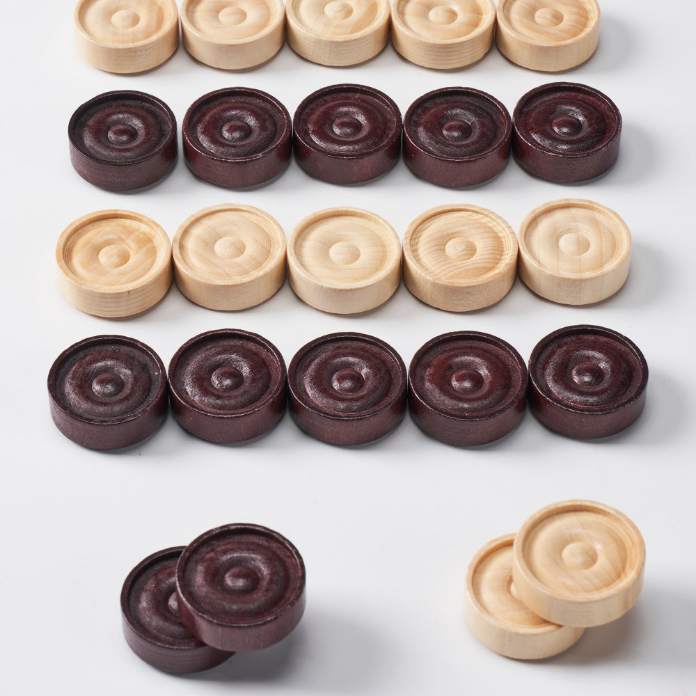 Wooden draughts pieces spread out next to drawstring bag 