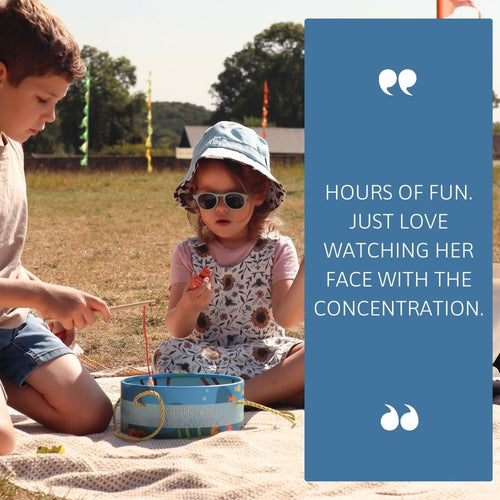 Two children sitting on a blanket outdoors with a blue text box containing a quote. 