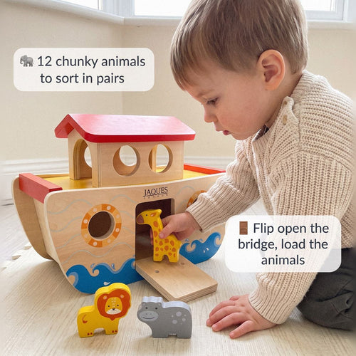 Toddler flipping open the bridge of the Jaques wooden Noah's Ark to load a wooden giraffe, with 12 chunky animals to sort in pairs 
