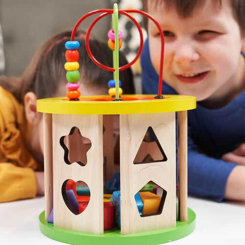  Children looking through holes of activity cube shape sorter 