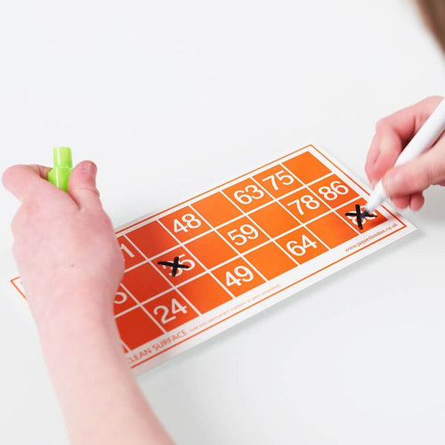  Child marking wipeable bingo card with whiteboard pen