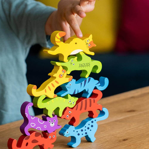 Bright wooden cat stacking toy for kids - child placing final yellow cat on top of the stack.   