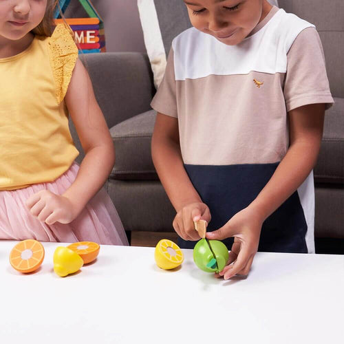  Little boy slicing pear with wooden knife