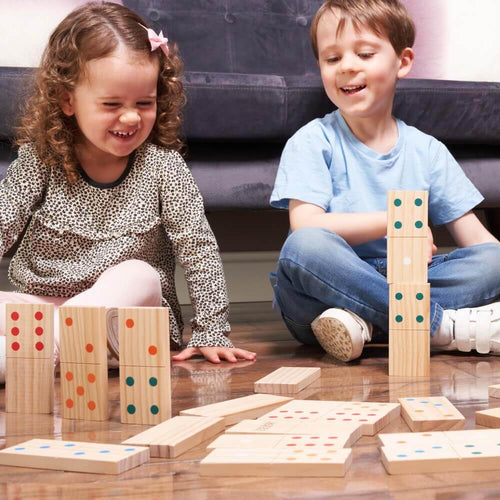 Children building and stacking giant wooden dominoes  