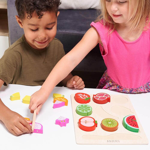 Children cutting wooden play food fruit together 