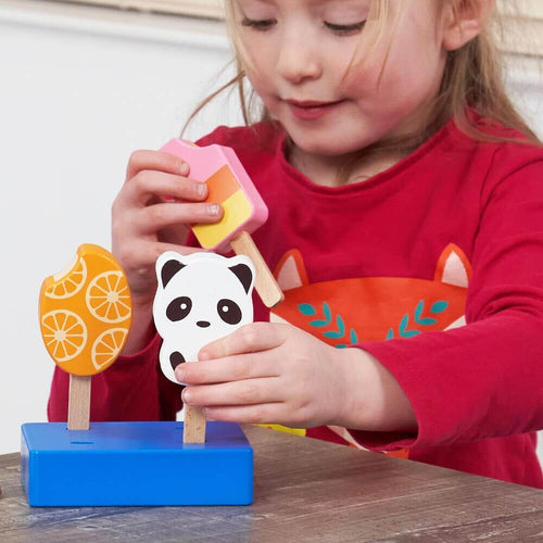  Child putting pretend food holiday lolly in display stand  