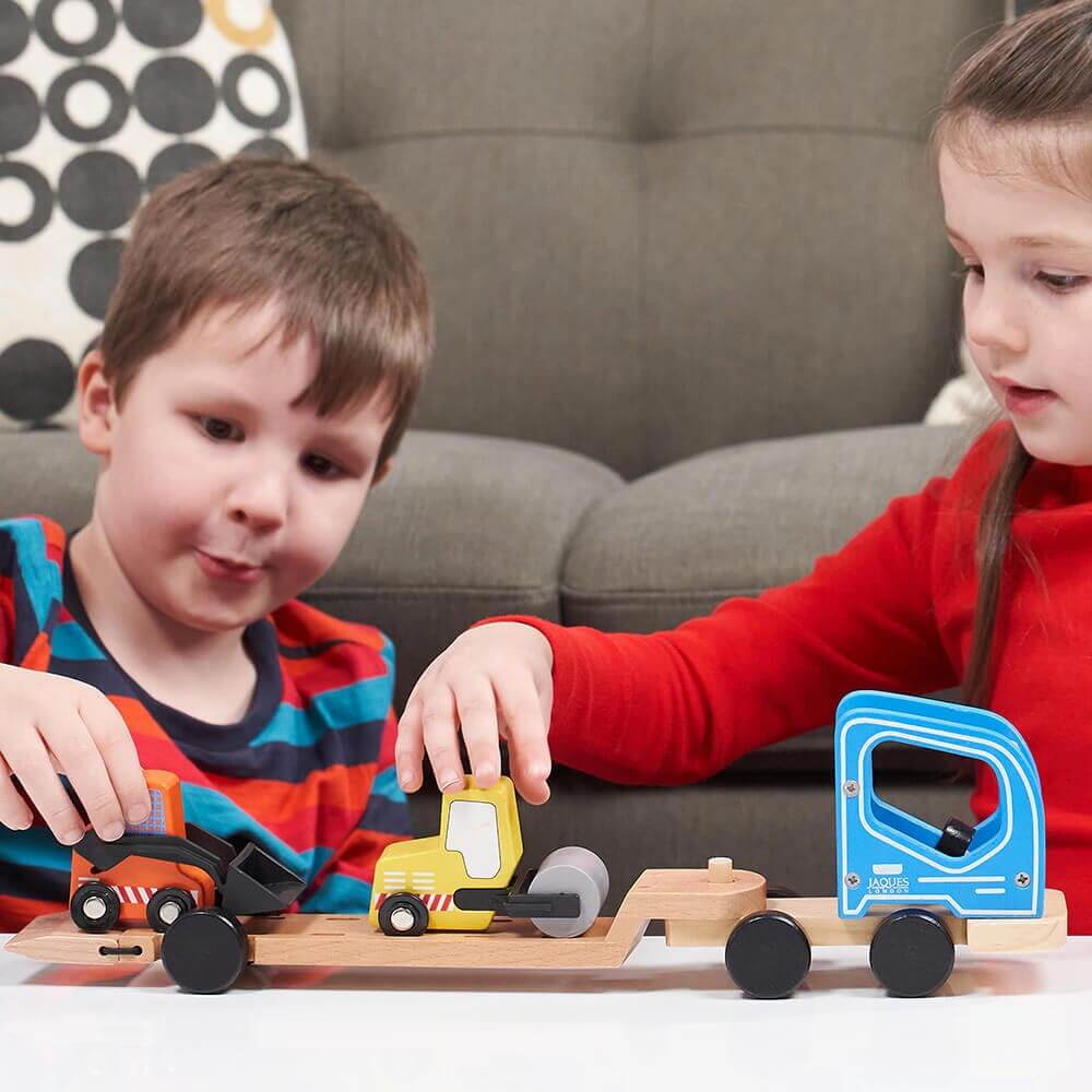  Children moving digger and road roller on to construction vehicle toy