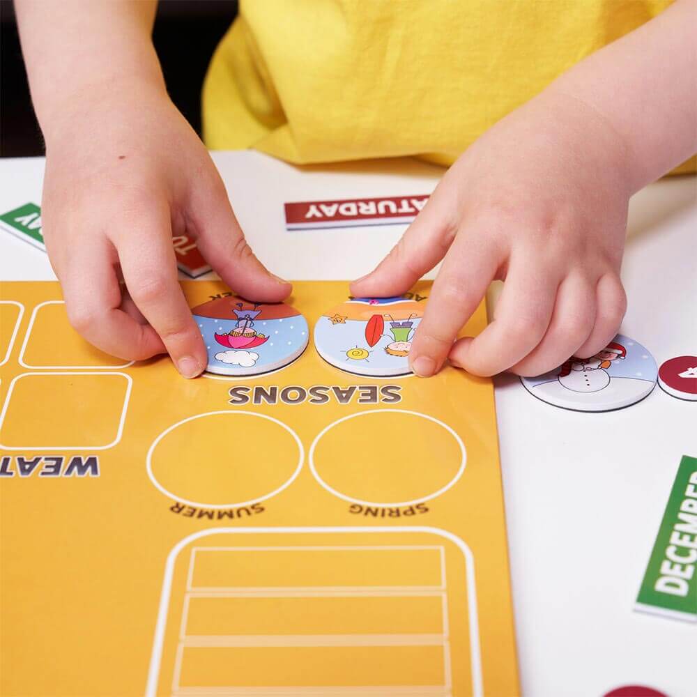 Child playing season magnets on first magnetic calendar 
