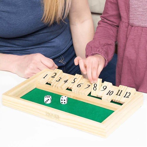  Little girl putting down a number tile as she plays shut the box 