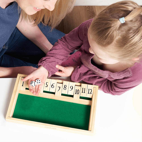  Child with dice in hand playing shut the both with mother