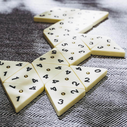  A close up of Triangle dominoes being played on a fabric surface 