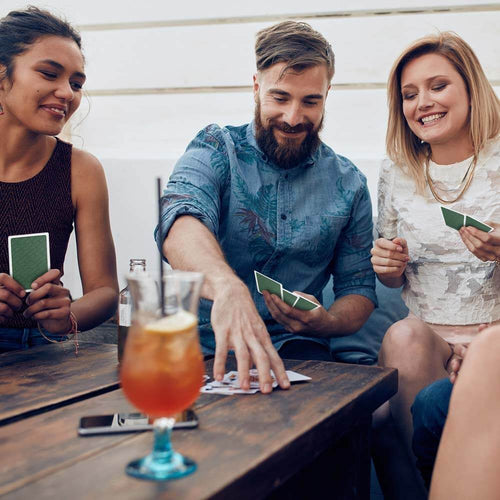 Adults playing cards in pub  