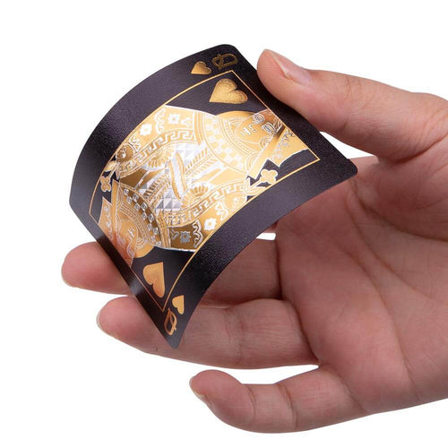 Hand holding gold queen of waterproof playing cards  